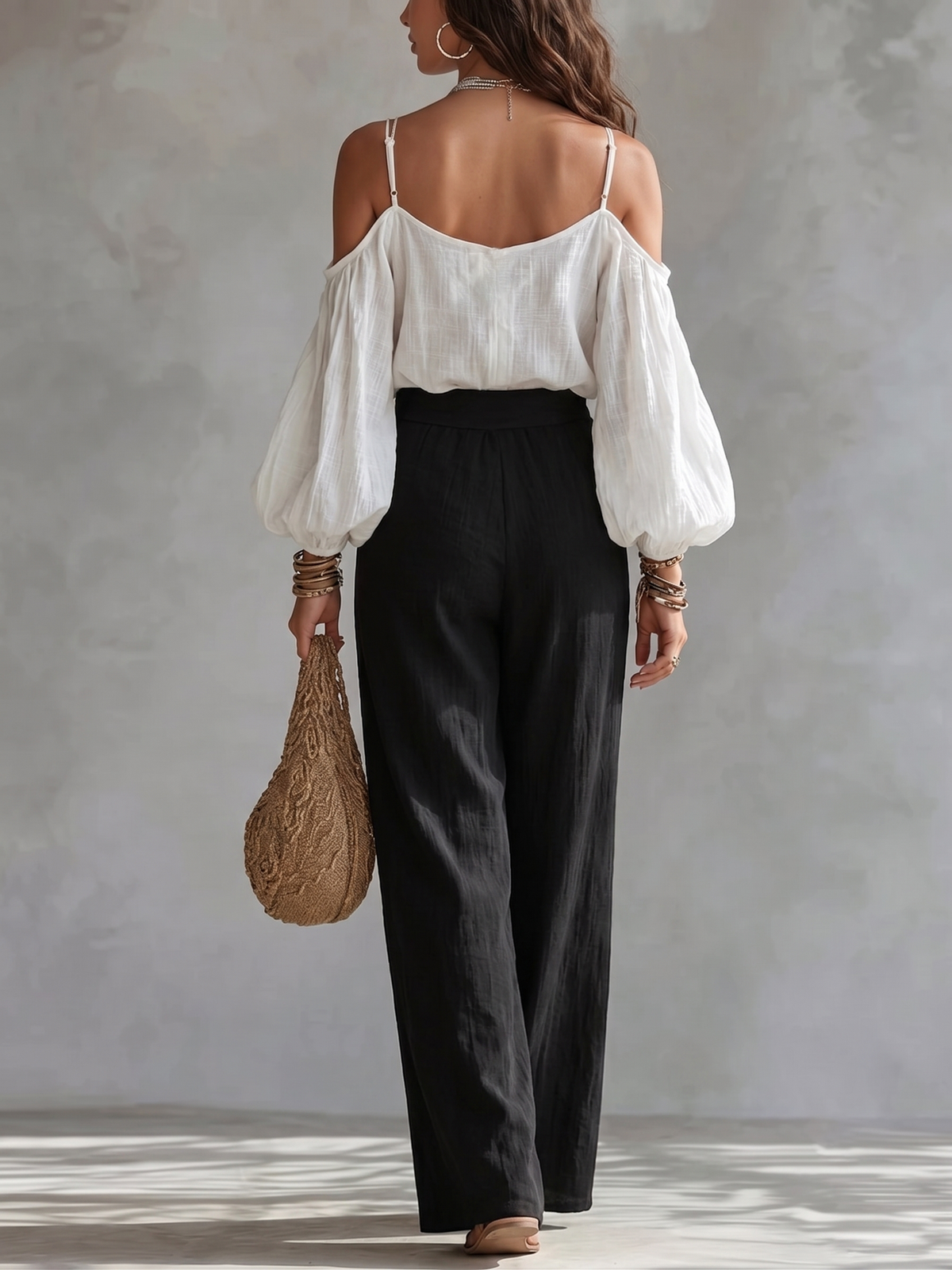 Top blanco de hombros descubiertos  y pantalón negro de pierna ancha